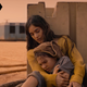 A mother, Ilsa (Sofia Boutella), embraces her daughter, Remmy (Brooklynn Prince), in front of their Martian homestead in Settlers.